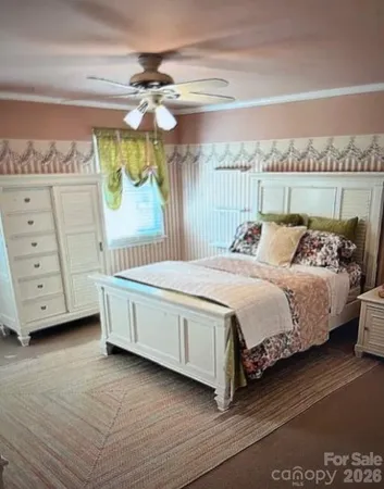 a spacious bedroom with a bed a dresser and a painting on the wall