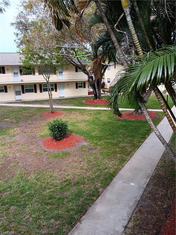 3325 Airport Road North, Unit H7 Naples, FL 34105 - Photo 14 of 15 a front view of a house with a yard and garage