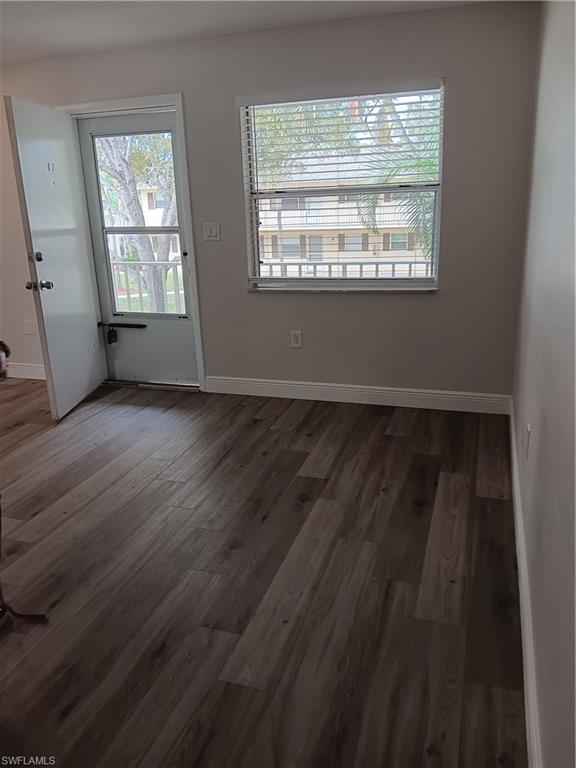 3325 Airport Road North, Unit H7 Naples, FL 34105 - Photo 3 of 15 a view of an empty room with wooden floor and a window