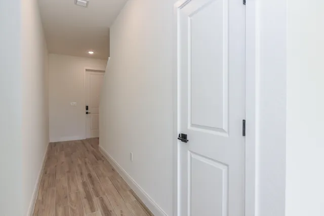 a view of a hallway with wooden floor and entryway