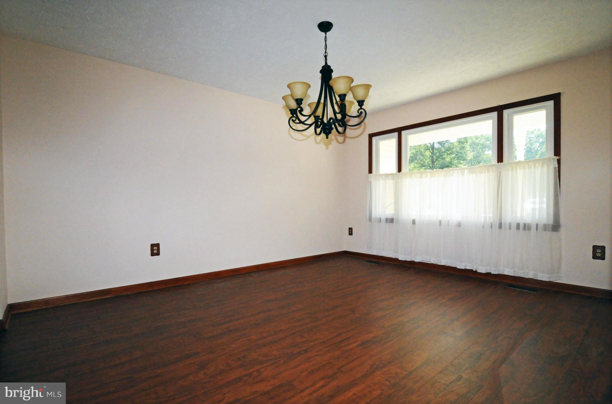 7881 Walnut Grove Road Severn, MD 21144 - Photo 4 of 21 a view of an empty room with wooden floor and a window