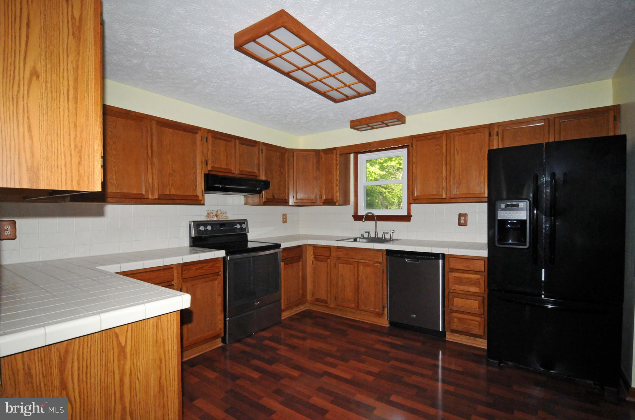 7881 Walnut Grove Road Severn, MD 21144 - Photo 6 of 21 a kitchen with stainless steel appliances granite countertop a refrigerator stove top oven and sink