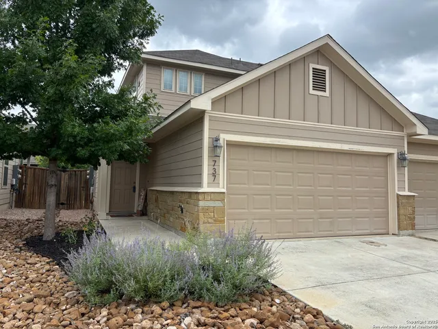 a small white house with a white roof and wooden fence