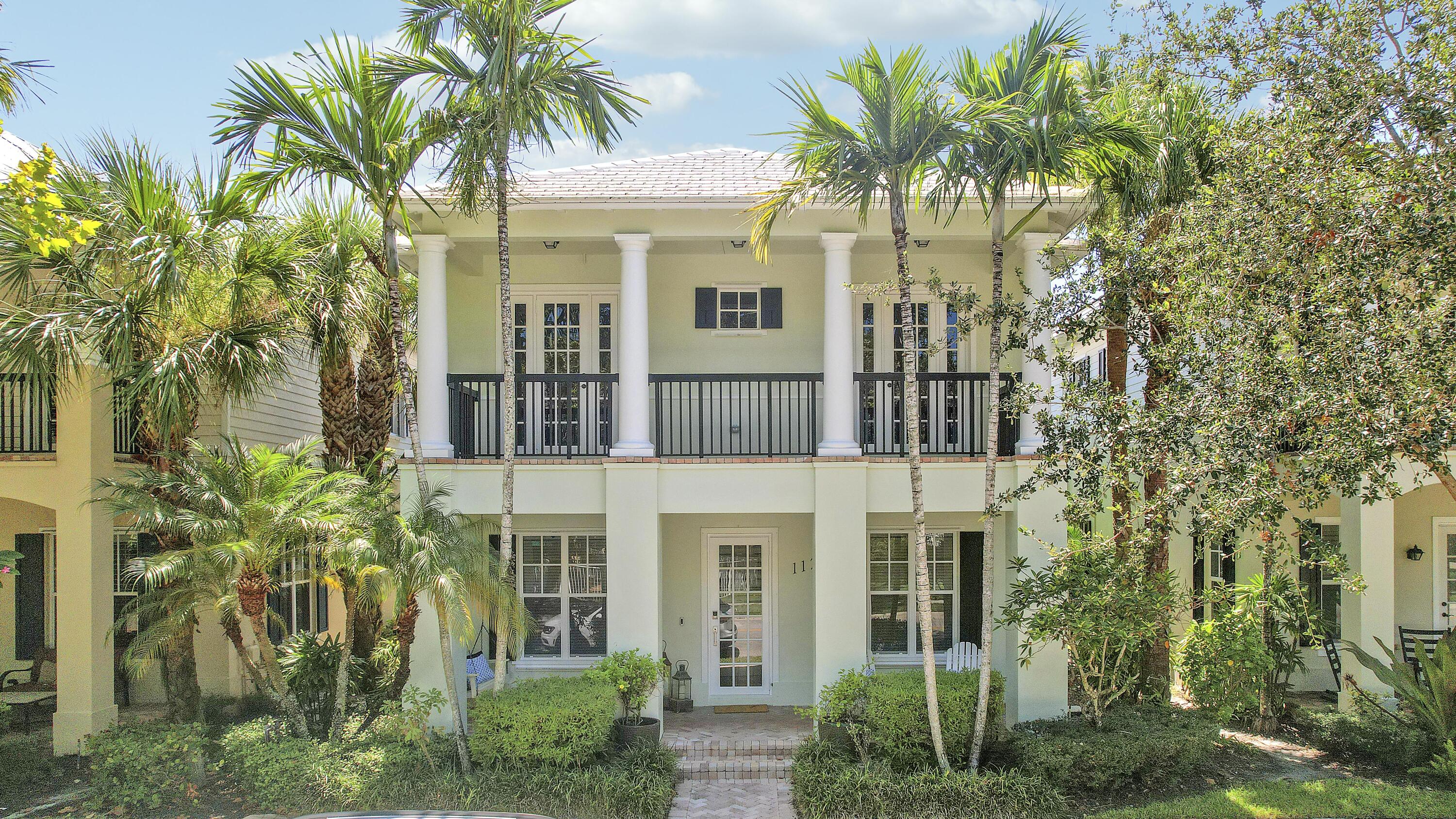 a view of a brick house with a large windows and plants
