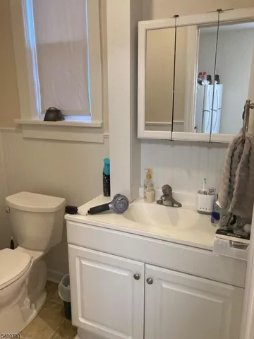 a bathroom with a granite countertop toilet sink and mirror
