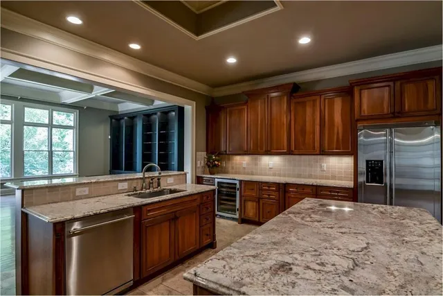 a large kitchen with kitchen island a sink stove and cabinets