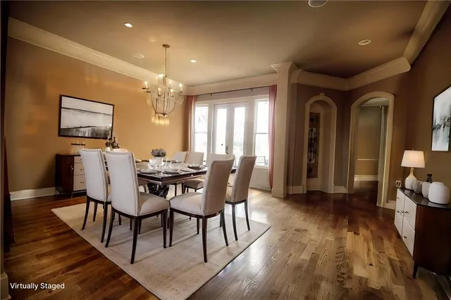 a dining room with furniture a chandelier and wooden floor