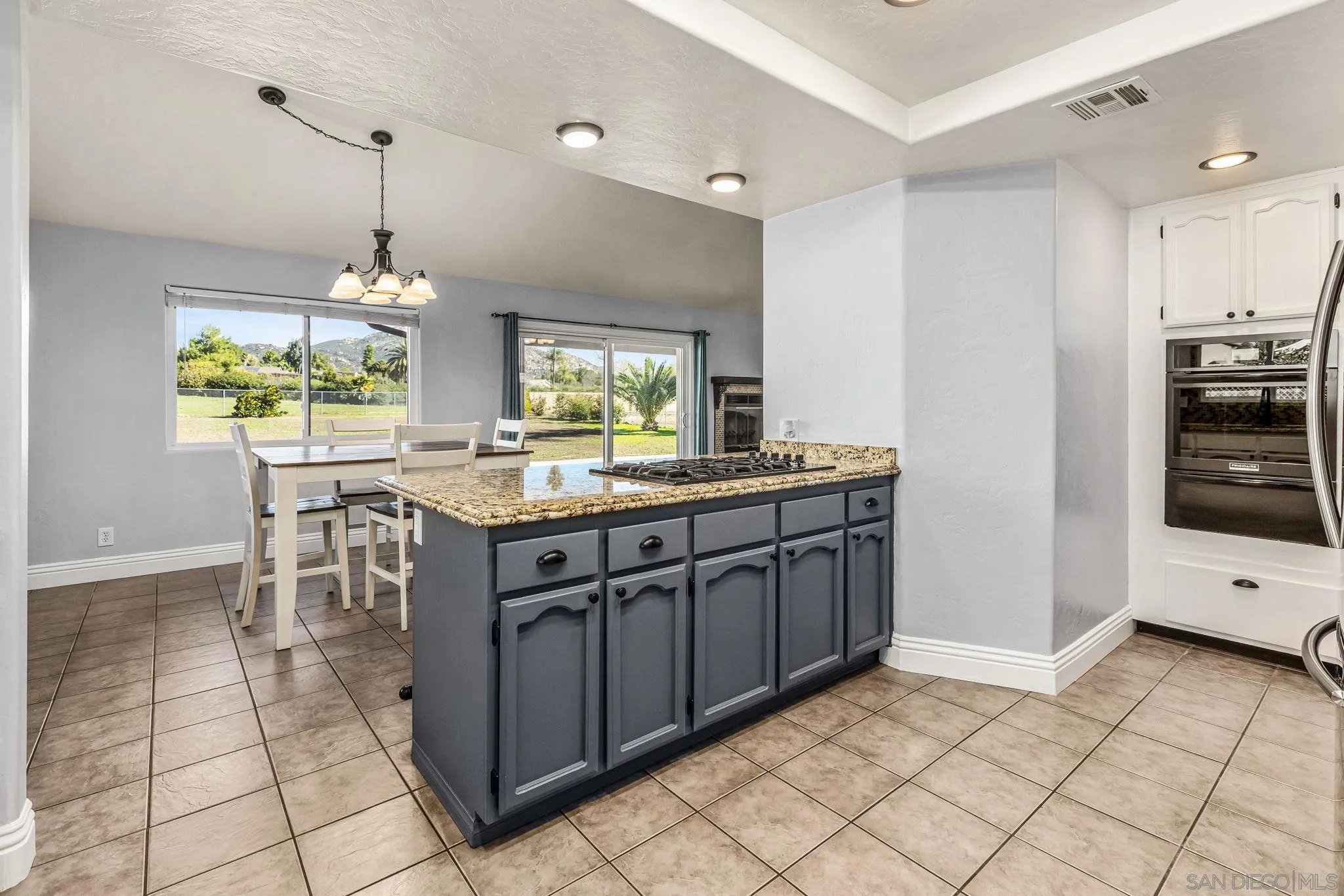 16319 Scarbery Road Ramona, CA 92065 - Photo 11 of 37 a kitchen with kitchen island granite countertop a stove a sink and a refrigerator