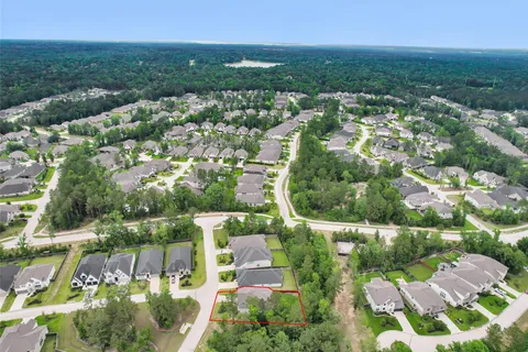 an aerial view of residential houses with outdoor space and trees