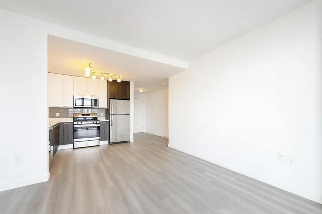 a kitchen with a refrigerator and a stove top oven
