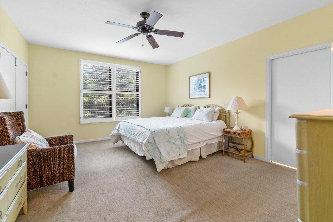 122 Andrews Avenue, Unit 2A Delray Beach, FL 33483 - Photo 14 of 39 a bedroom with a bed a couch and a chandelier