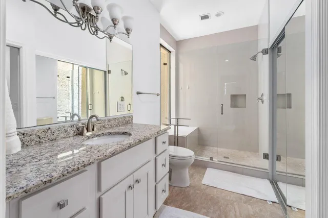 a bathroom with a granite countertop sink toilet and shower