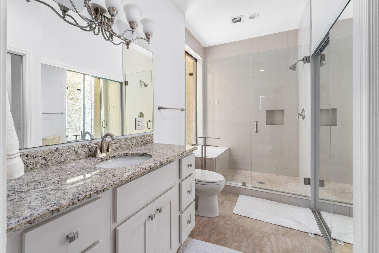 122 Andrews Avenue, Unit 2A Delray Beach, FL 33483 - Photo 16 of 39 a bathroom with a granite countertop sink toilet and shower