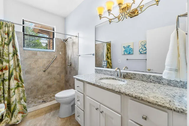 a bathroom with a granite countertop sink a toilet and a mirror