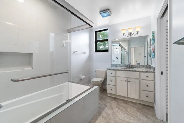 a bathroom with a tub a double vanity sink and mirror