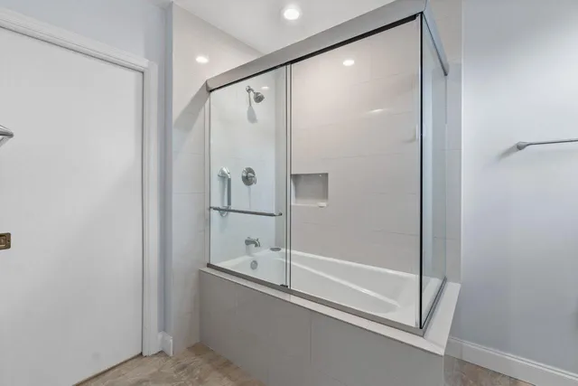 a bathroom with a glass shower door and a sink