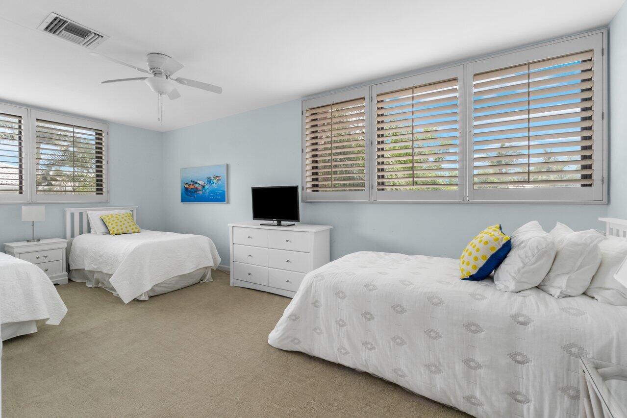 122 Andrews Avenue, Unit 2A Delray Beach, FL 33483 - Photo 22 of 39 a bedroom with two bed and a window