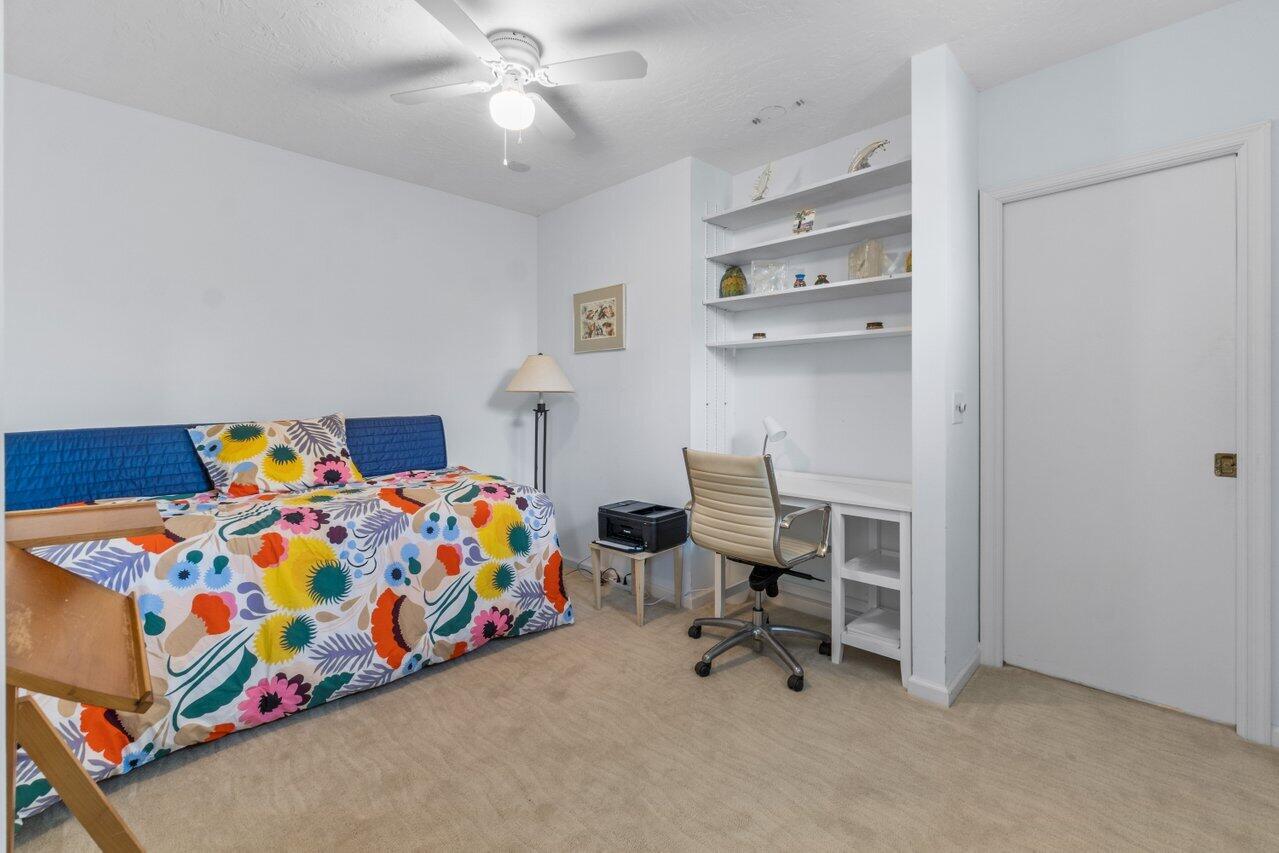 122 Andrews Avenue, Unit 2A Delray Beach, FL 33483 - Photo 24 of 39 a bedroom with a bed and a chandelier