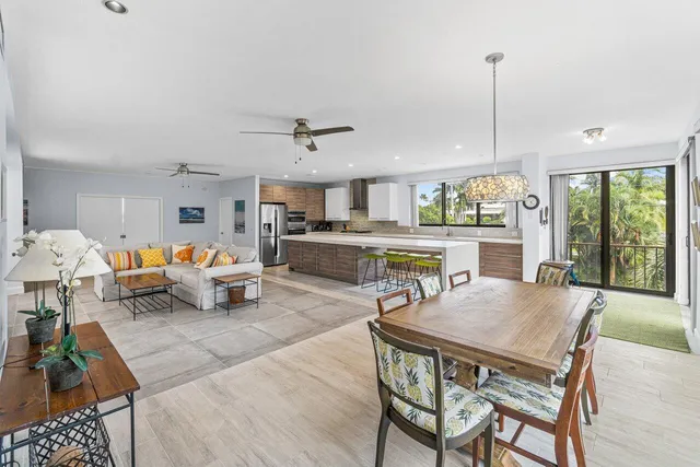 a living room with furniture kitchen view and a large window