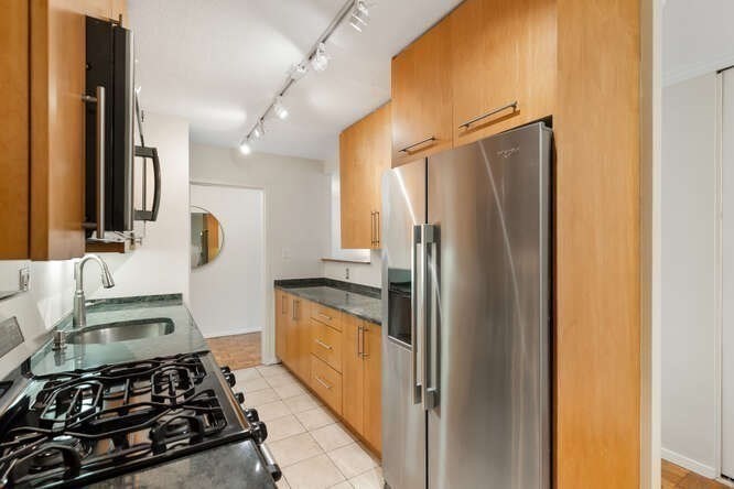 2 Hawthorne Place, Unit 16M Boston, MA 02114 - Photo 12 of 36 a kitchen with stainless steel appliances granite countertop a refrigerator and a sink