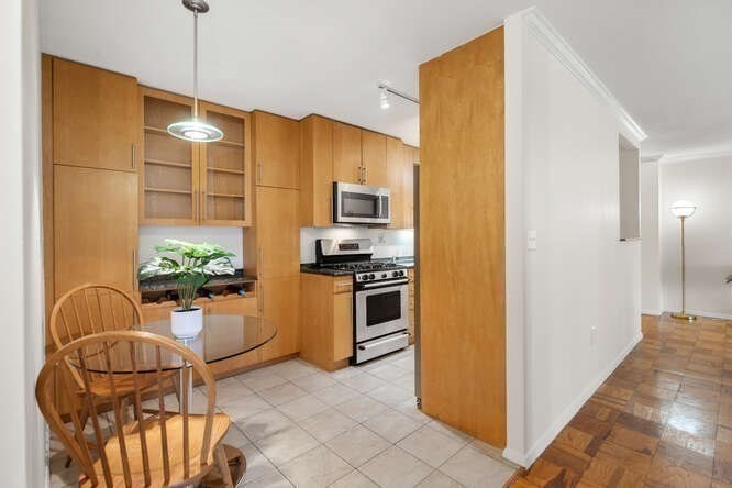 2 Hawthorne Place, Unit 16M Boston, MA 02114 - Photo 14 of 36 a kitchen with stainless steel appliances granite countertop a stove a refrigerator and a dining table