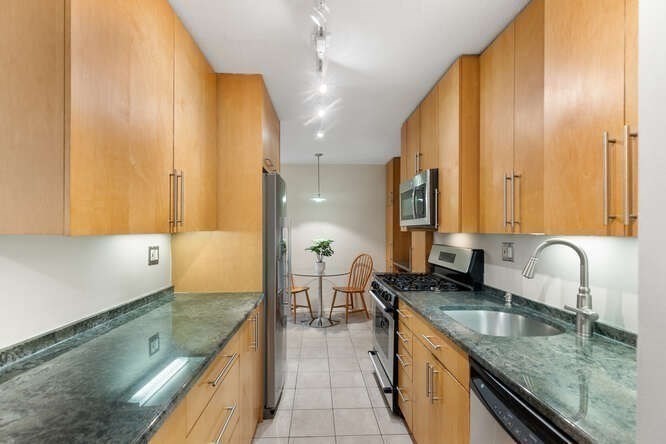 2 Hawthorne Place, Unit 16M Boston, MA 02114 - Photo 9 of 36 a kitchen with granite countertop a sink a counter top space appliances and cabinets
