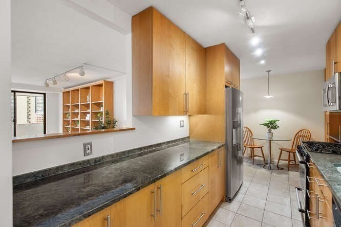 2 Hawthorne Place, Unit 16M Boston, MA 02114 - Photo 10 of 36 a large kitchen with granite countertop a sink and a stove