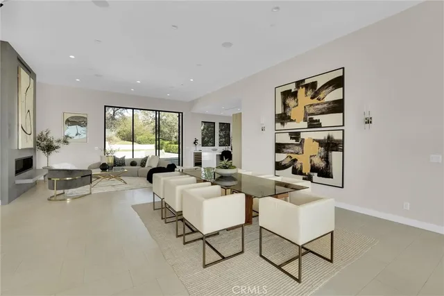 a living room with furniture kitchen view and large windows