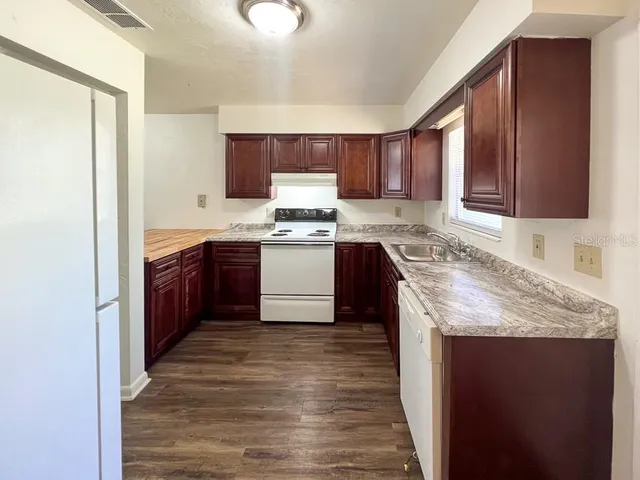 a kitchen with stainless steel appliances granite countertop wooden cabinets a sink and dishwasher