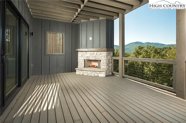 an empty room with wooden floor fireplace and windows