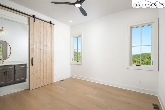 an empty room with windows cabinet and mirror