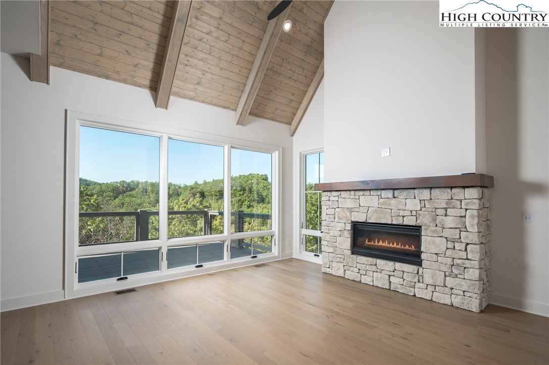 359 Calico Court Boone, NC 28607 - Photo 4 of 50 a view of an empty room with wooden floor fireplace and a window