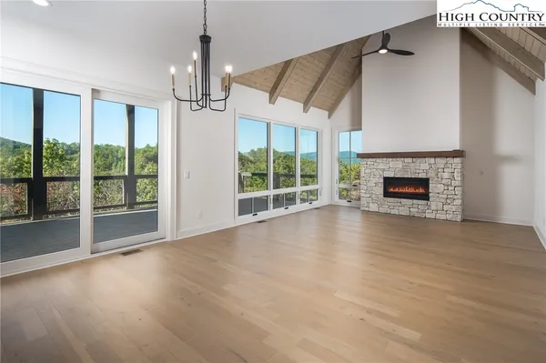 a view of empty room with wooden floor and fireplace