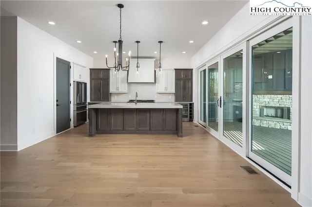 a large kitchen with kitchen island a large window and stainless steel appliances