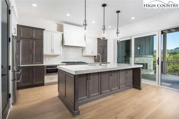 a kitchen with stainless steel appliances granite countertop a refrigerator a sink and a oven