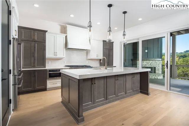 a kitchen with stainless steel appliances granite countertop a refrigerator a sink and a oven