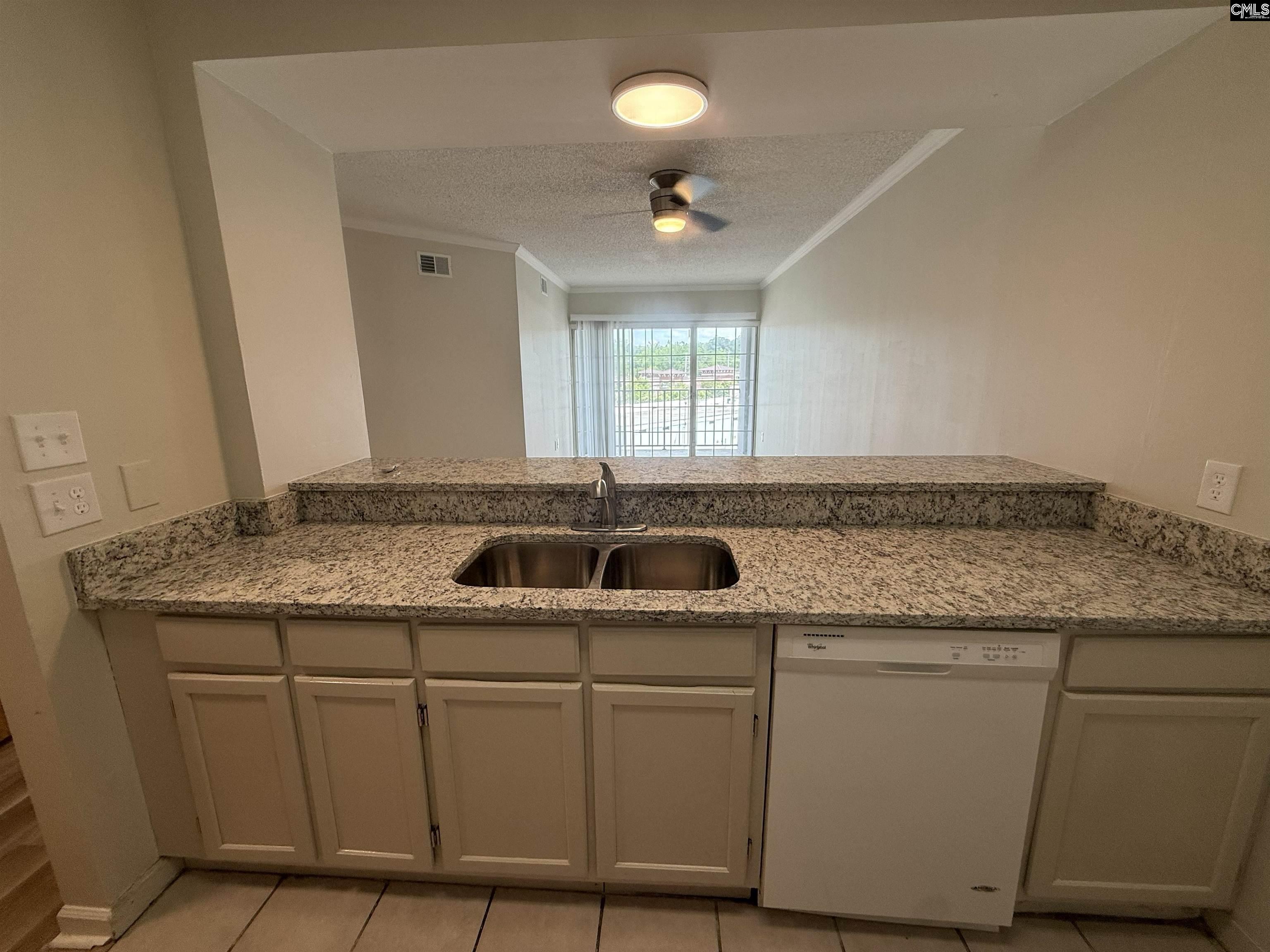 2002 Greene Street, Unit 209 Columbia, SC 29205 - Photo 16 of 22 a kitchen with granite countertop a sink and white cabinets