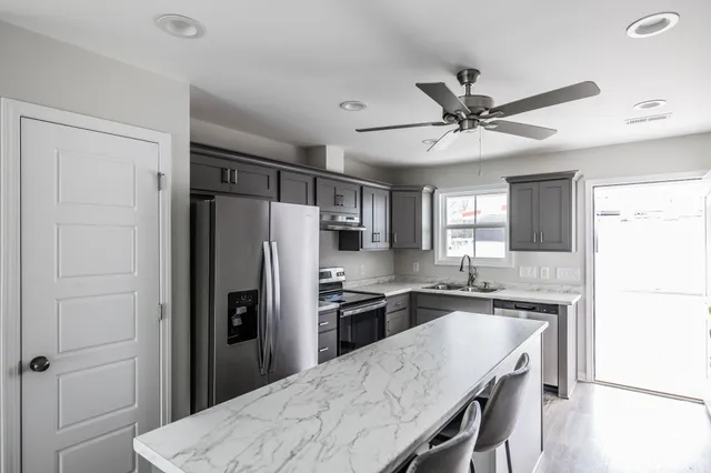 a kitchen with granite countertop a refrigerator and a sink