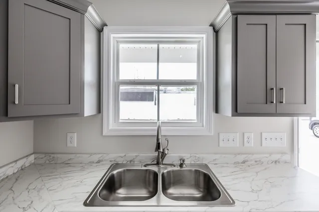 a kitchen with sink a window and cabinets