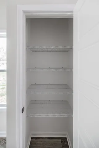 a view of walk in closet with empty racks