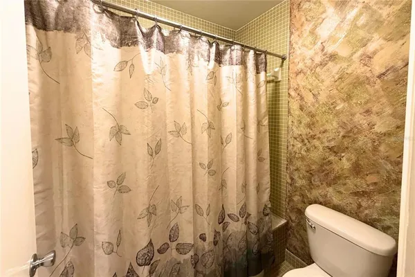 a white toilet sitting next to a shower curtain
