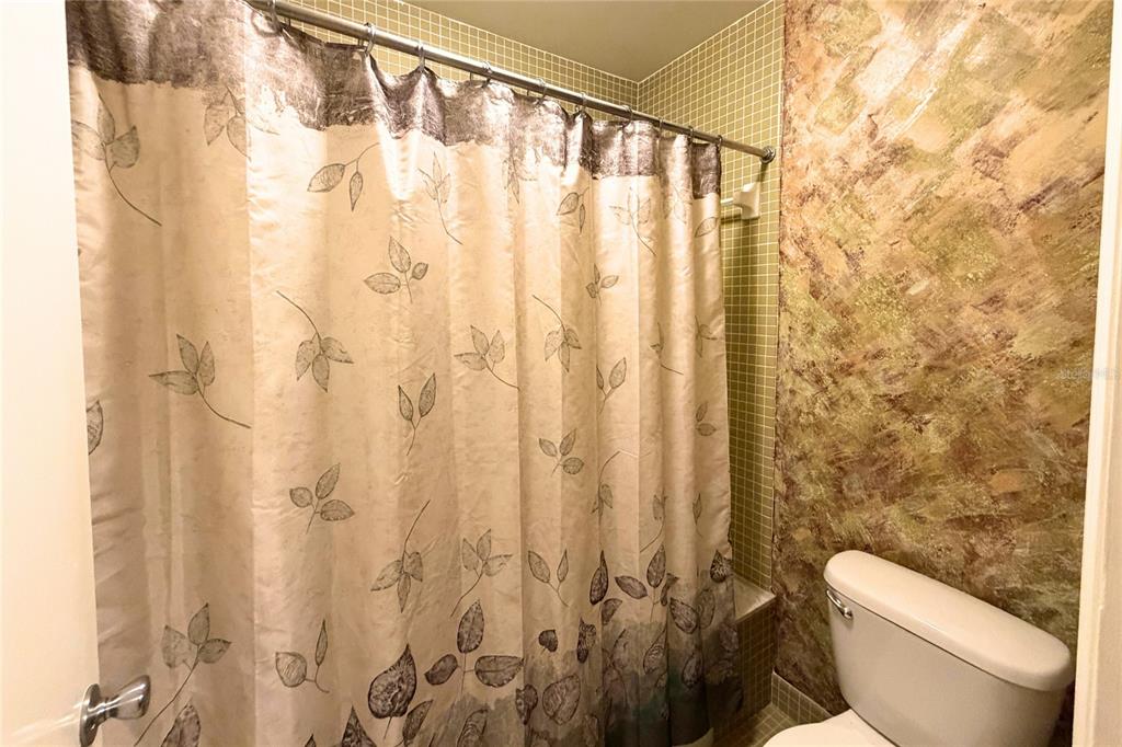 701 Poinsettia Road, Unit 340 Belleair, FL 33756 - Photo 12 of 24 a white toilet sitting next to a shower curtain