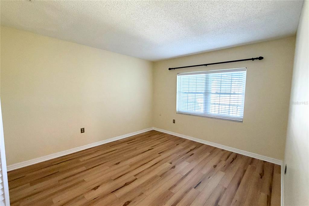 701 Poinsettia Road, Unit 340 Belleair, FL 33756 - Photo 14 of 24 an empty room with wooden floor and windows