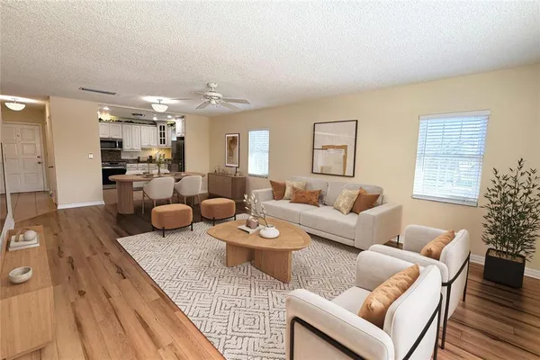 a living room with furniture and a dining table with wooden floor