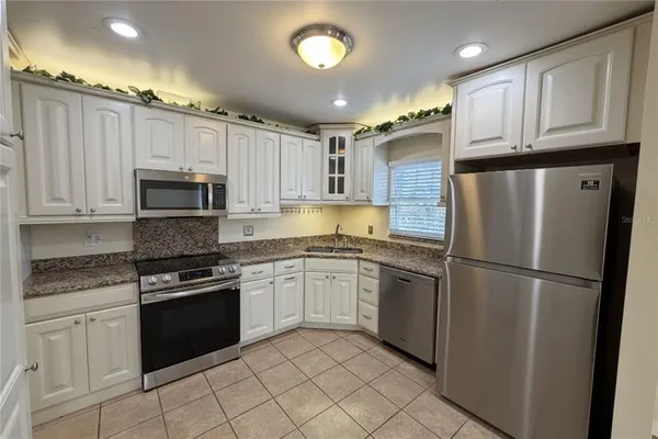 a kitchen with granite countertop stainless steel appliances and wooden cabinets