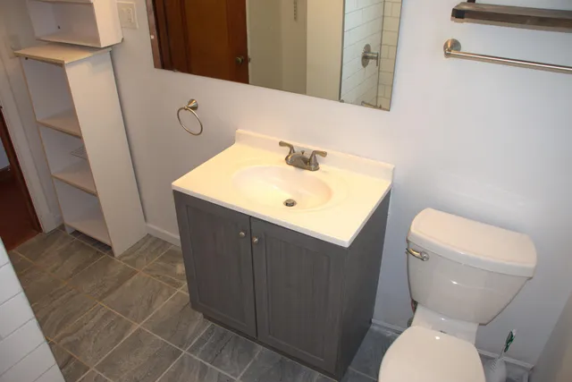 a bathroom with a toilet sink and mirror