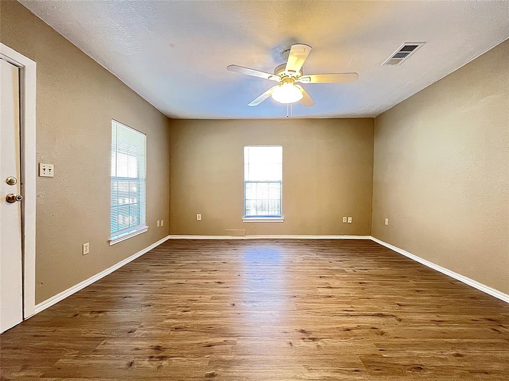503 Pierce Street Denton, TX 76201 - Photo 2 of 12 a view of an empty room with window and wooden floor