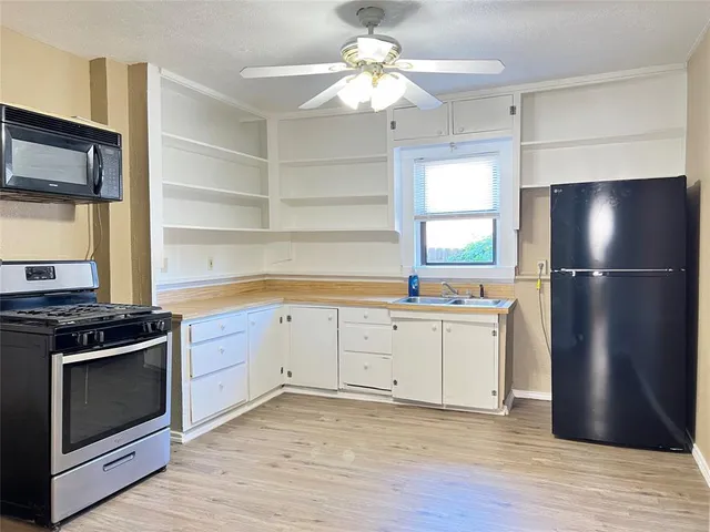 a kitchen with a stove refrigerator and a microwave