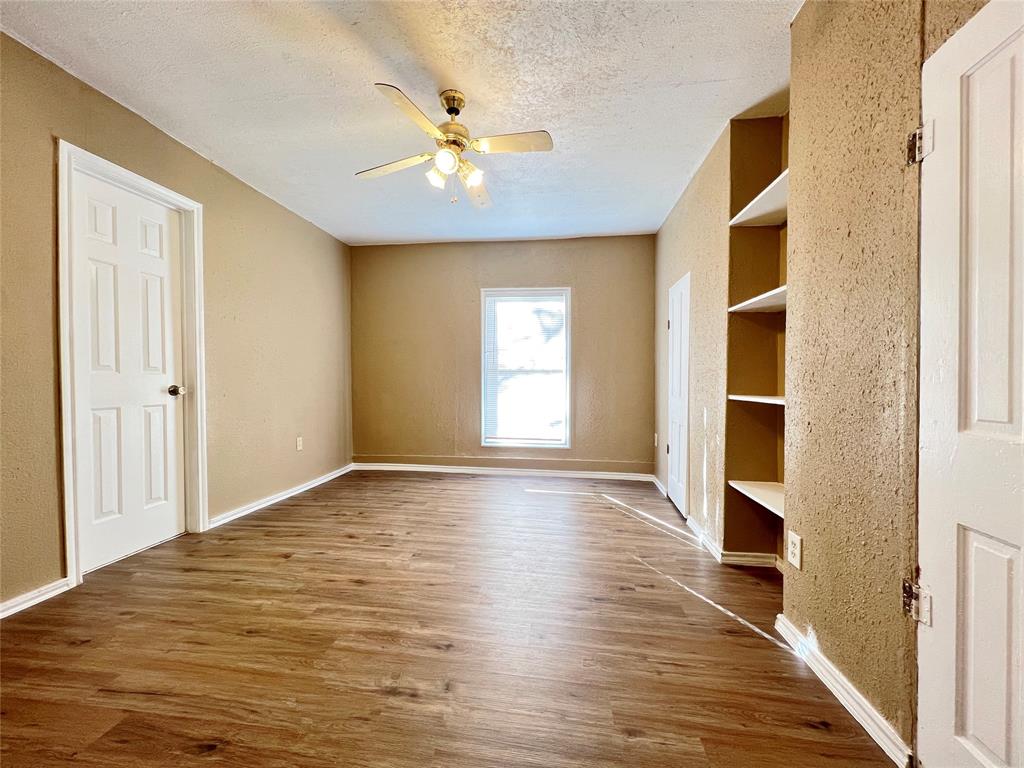 503 Pierce Street Denton, TX 76201 - Photo 6 of 12 a view of an empty room with a window and wooden floor