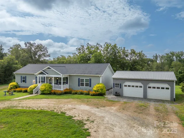 a view of a house with a big yard and large trees